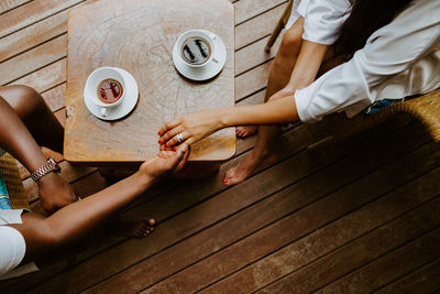 Midsection of woman with coffee cup on table