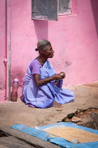 Full length of woman sitting on wall