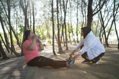 Side view of young woman sitting at park