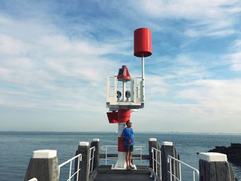 Man standing against lighthouse at beach