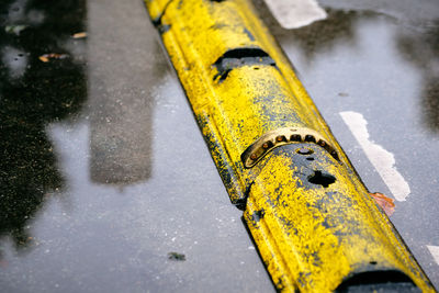 High angle view of yellow arrow sign on road in city