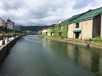 River amidst city against sky