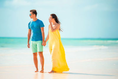 Rear view of woman standing at beach