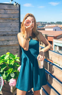 Young woman standing against wooden wall