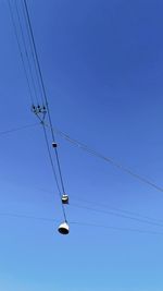 Low angle view of power cable against clear blue sky