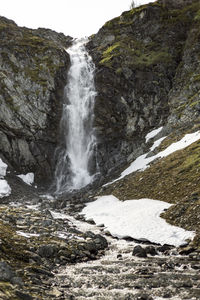 Scenic view of waterfall against sky