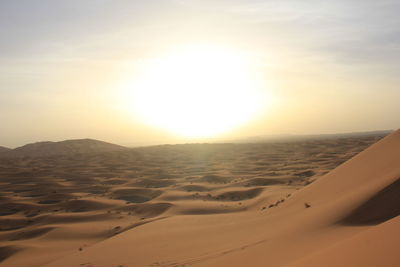 Scenic view of desert against sky during sunset