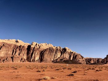 Rock formations in desert against clear blue sky