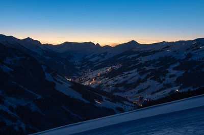 Scenic view of snowcapped mountains against clear sky during winter