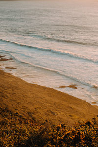 Aerial shot of a massive beach with waves during a super sunny sunset on vintage tones