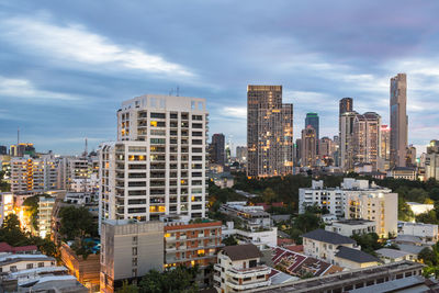 Skyscrapers in city against cloudy sky