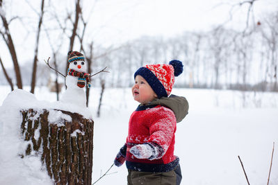 Portrait of girl standing on snow covered field