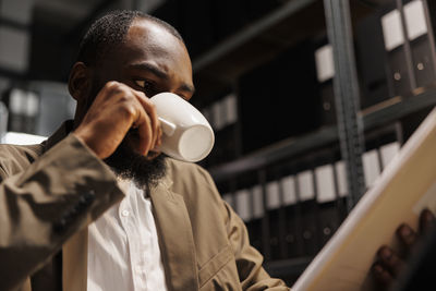 Side view of man drinking coffee in cafe