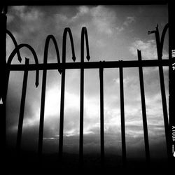 Low angle view of fence against sky