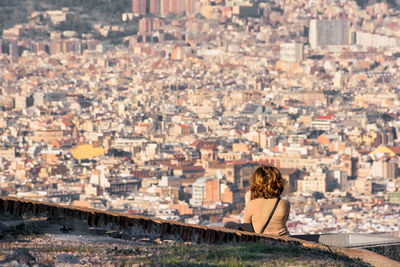 Rear view of woman looking at city buildings in barcelona 