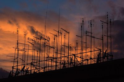 Silhouette electricity pylon against sky during sunset