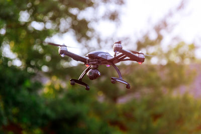 Drone flying against trees