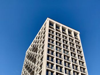 Low angle view of modern building against clear blue sky