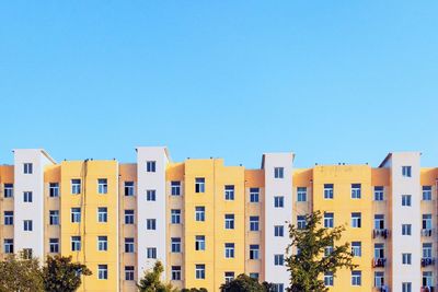 Low angle view of buildings against clear blue sky