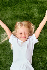 Portrait of cute girl sitting on grassy field