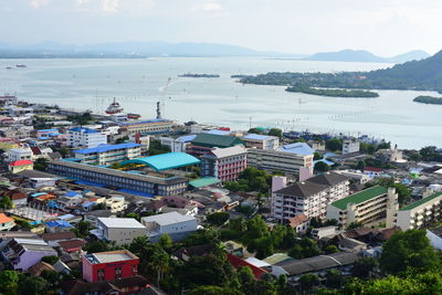 High angle view of townscape by sea against sky