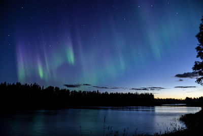 Scenic view of lake against sky at night