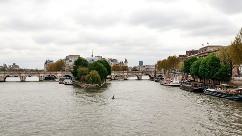 Bridge over river against cloudy sky