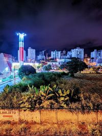 Illuminated buildings against sky at night