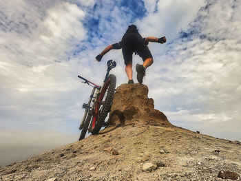 Low angle view of man on rock against sky