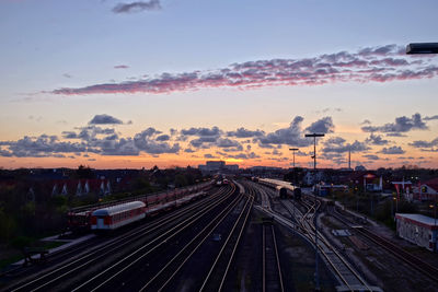 Railroad tracks against sky during sunset