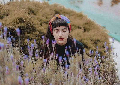 Woman with eyes closed by purple flowering plant