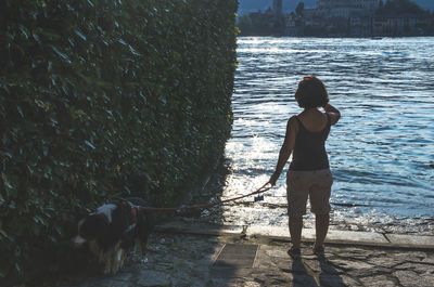 Woman with dog standing in water