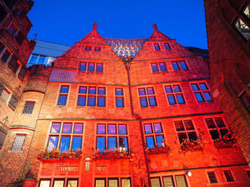 Low angle view of illuminated building against blue sky