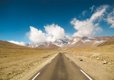 Panoramic view of road amidst mountains against  blue sky