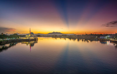 View of buildings at waterfront during sunset