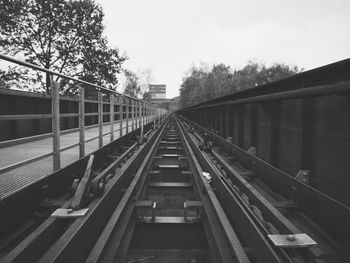 Railroad tracks in city against sky