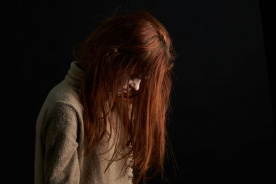 Young woman against black background