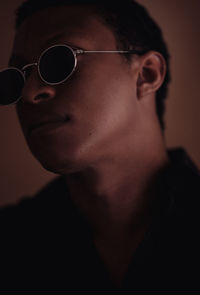 Close-up of man wearing sunglasses against wall