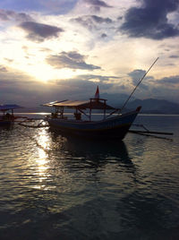 Boats in sea at sunset