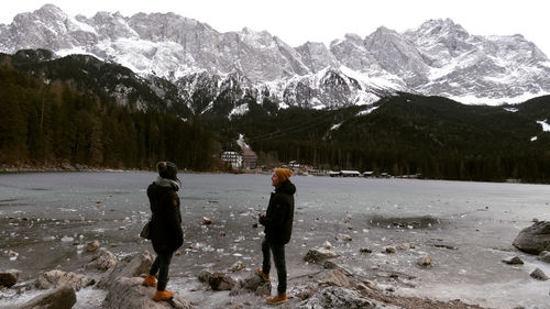 People standing by frozen lake