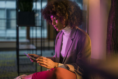 Businesswoman using tablet pc in illuminated office