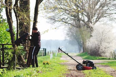 Boy with gardening equipment on pathway