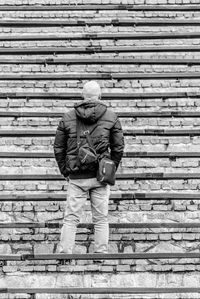 Rear view of man standing on staircase