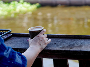 Cropped image of hand holding coffee cup