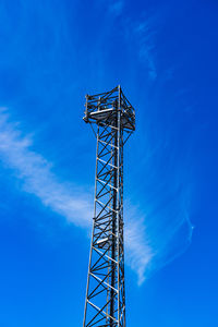 Low angle view of communications tower against blue sky