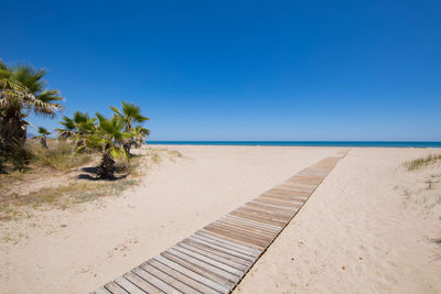 Scenic view of beach against clear blue sky