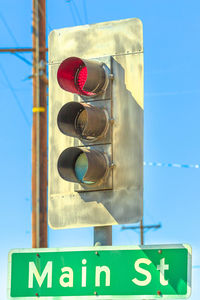 Low angle view of road sign against blue sky