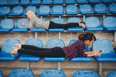 Full length of couple sitting on seat