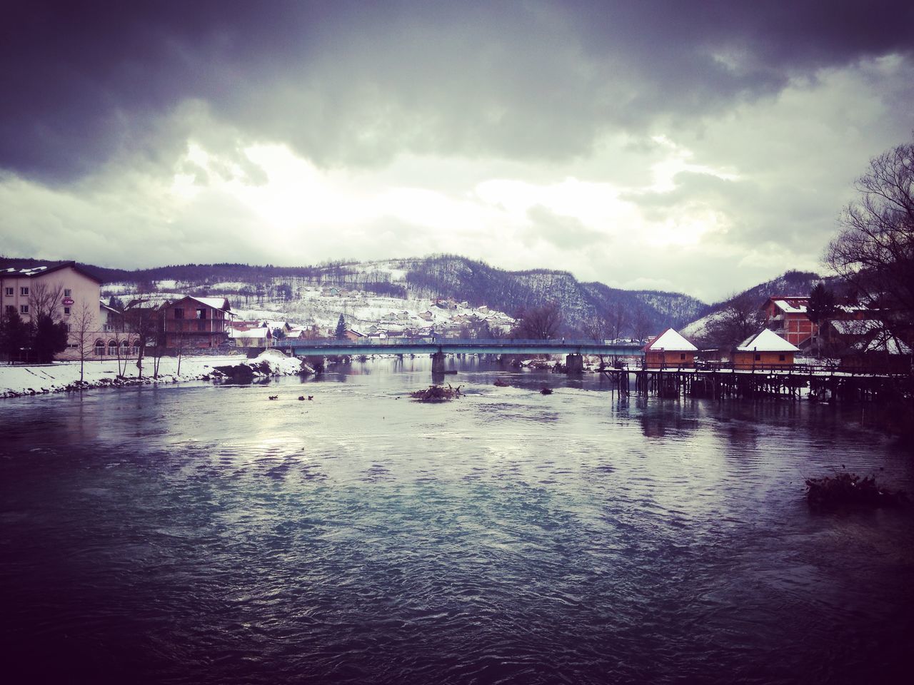 sky, water, cloud - sky, built structure, architecture, mountain, building exterior, waterfront, cloudy, cloud, river, tranquil scene, scenics, lake, tranquility, nature, beauty in nature, sea, house, mountain range