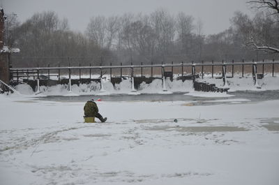 Man standing on snow covered field against sky